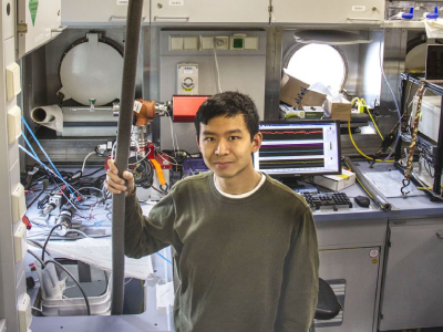 The R/V <em>Falkor</em> contains wet and dry laboratory space, a control room for sonar and ROV operations, and offices. Here, Seaver Wang supplies water to a mass spectrometer in the Wet Lab. Credit: Monika Naranjo Gonzalez (SOI)