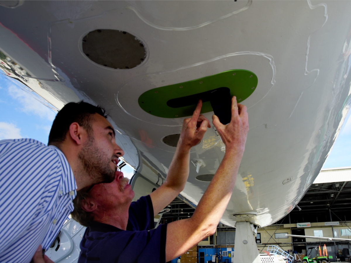 CORAL team members examine PRISM, an airborne instrument that measures the spectra of light