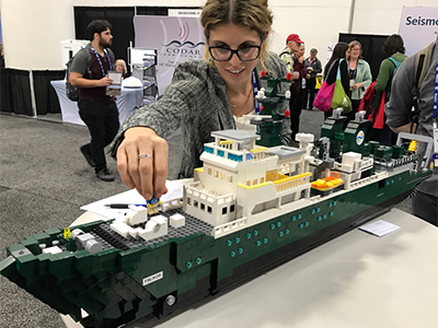 Carlie Wiener (SOI) examines a model of the <em>R/V Falkor</em> made out of legos