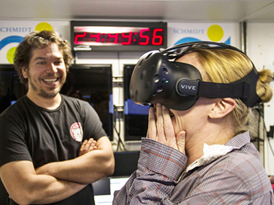 Melissa Omand reacts to the first virtual reality experience created on board R/V <em>Falkor</em>: holographic images of plankton suspended in the water. Credit: SOI