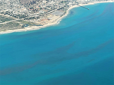 A view of the California Coast as seen from the Navy Postgraduate School (NPS) CIRPAS Twin Otter aircraft. Suspected red tide can be seen throughout the water.