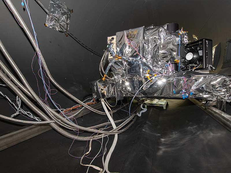 The OCI ETU rolls into the TVAC chamber. Lines are for electrical connections, temperature sensors, accelerometers, and liquid nitrogen, whic is used for cooling down the radiators.