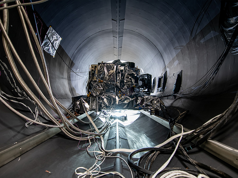 The OCI ETU rolls into the TVAC chamber. Lines are for electrical connections, temperature sensors, accelerometers, and liquid nitrogen, whic is used for cooling down the radiators.