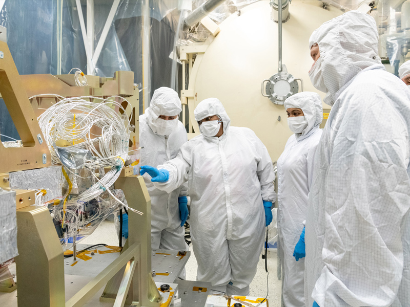 Blanket technicians discuss thermal templates on the Ocean Color Instrument Instrument Deck Structure (IDS) at Goddard Space Flight Center. Credit: Mellos, Katherine