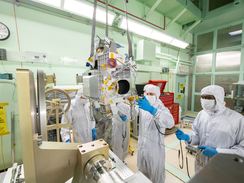 Mechanical technician Joseph Eddy guides the Ocean Color Instrument Main Optics Bench (MOB) to the LISARD turnover fixture overseen by quality engineer George Brooks. Credit: Stover, Desiree