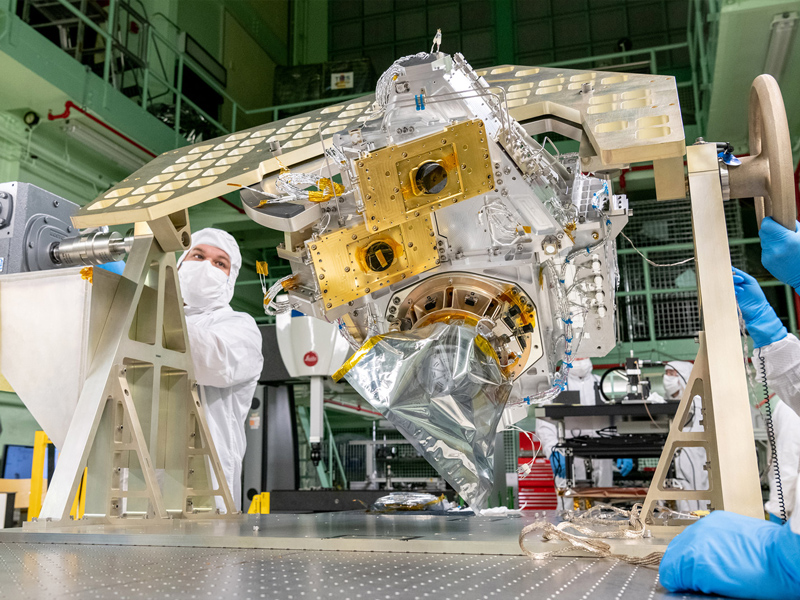 Mechanical technicians reorient the Ocean Color Instrument Optical Module on the rotation fixture for additional hardware integration. Credit: Mellos, Katherine