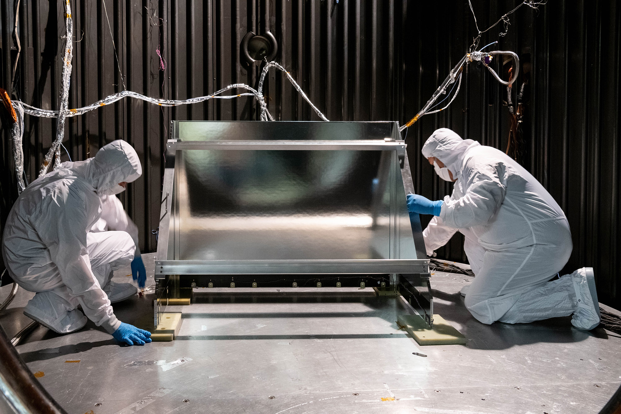 Mechanical Technicians Daniel Dizon and Joseph Eddy install the Ocean Color Instrument Earth Shade into the thermal vacuum chamber.