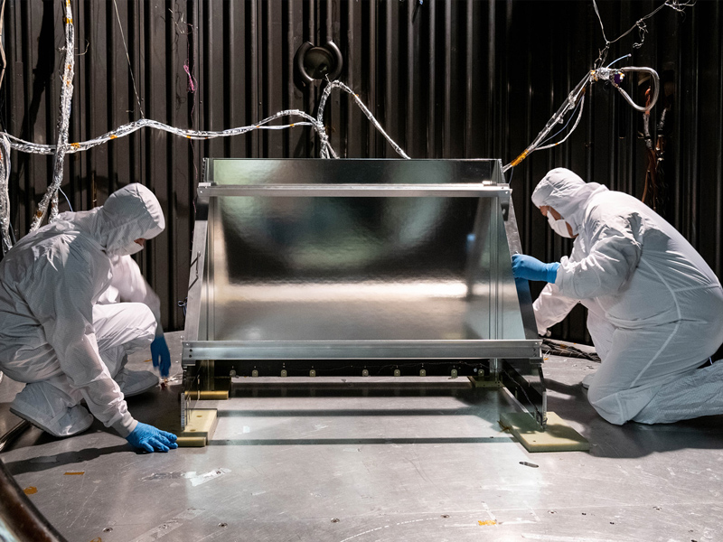 Mechanical Technicians Daniel Dizon and Joseph Eddy install the Ocean Color Instrument Earth Shade into the thermal vacuum chamber. Credit: Mellos, Katherine