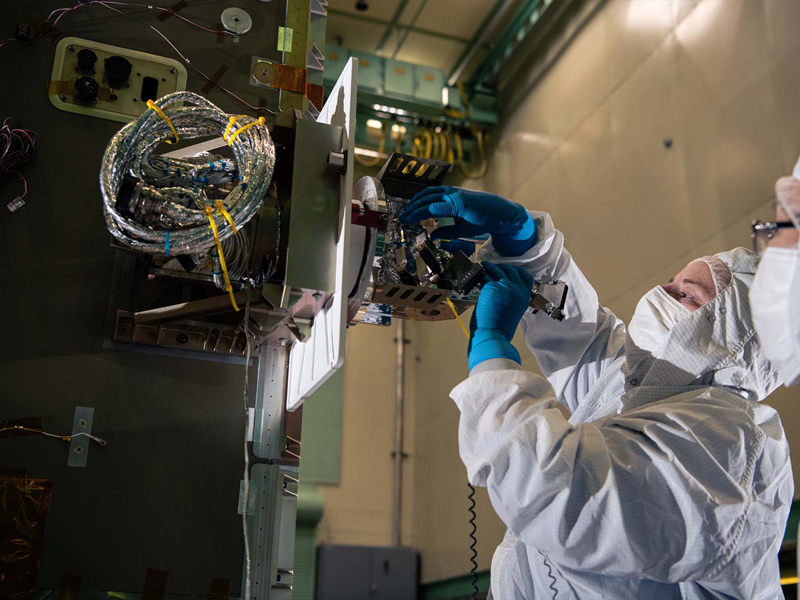Installing the solar array drive assembly on the PACE spacecraft bus.