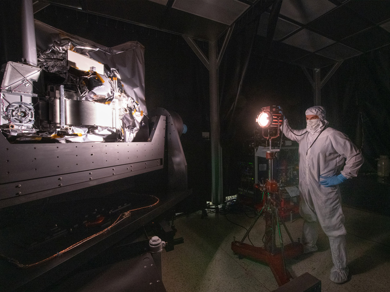 Systems engineer, Joseph Knuble, adjusts the intensity of the studio lamp during the Ocean Color Instrument stray light testing. Credit: Stover, Desiree