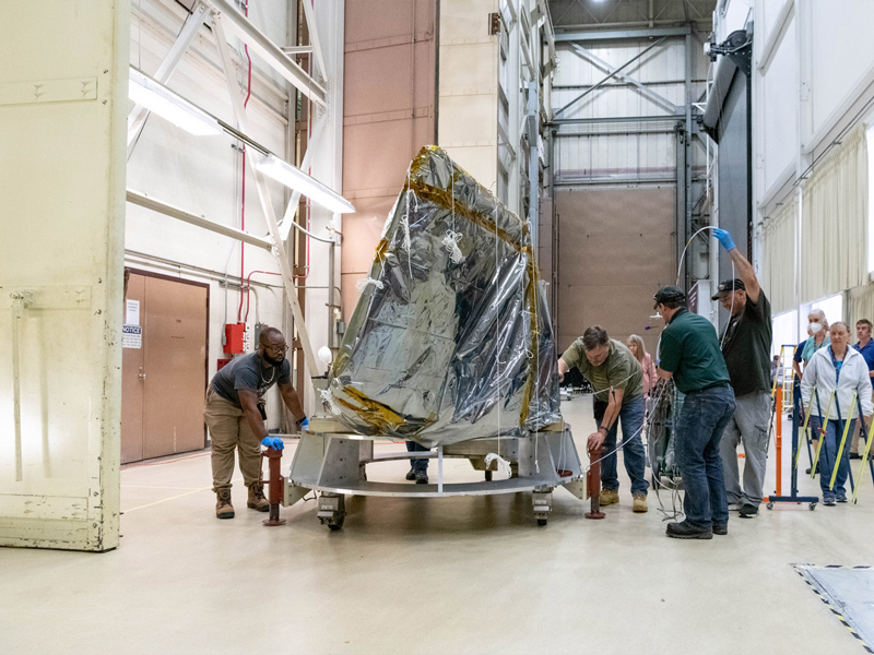 Mechanical technicians transport the Ocean Color Instrument through the integration and testing complex to X-Axis (vertical) vibration chamber. Credit: Mellos, Katherine
