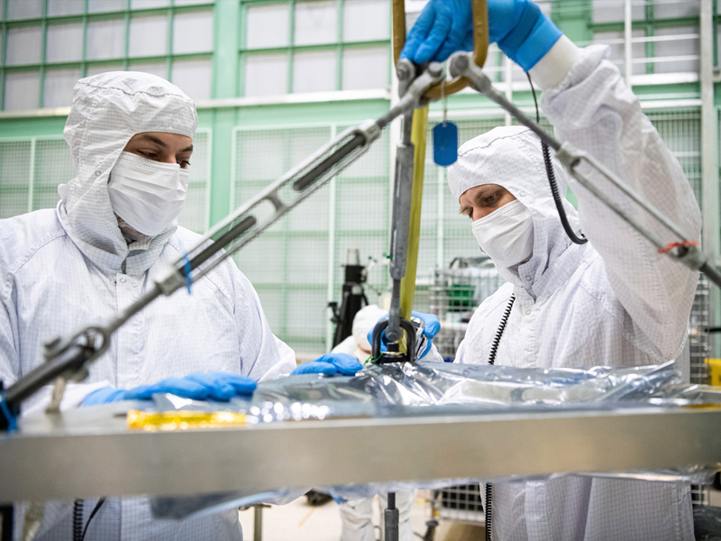 Mechanical engineer, Eduardo Rodriguez, and Mechanical Technician, Joe Eddy, prepare the vertical lift sling to crane lift the Ocean Color Instrument. Credit: Henry, Dennis (Denny)