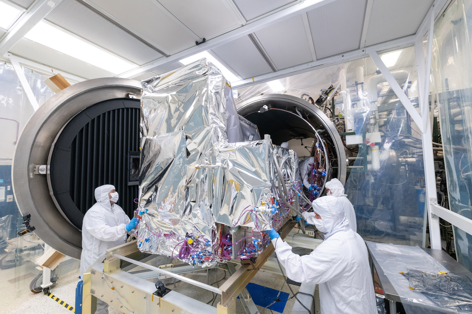 The Ocean Color Instrument team pushes the instrument into the Thermal Vacuum Chamber (TVAC) for environmental testing.