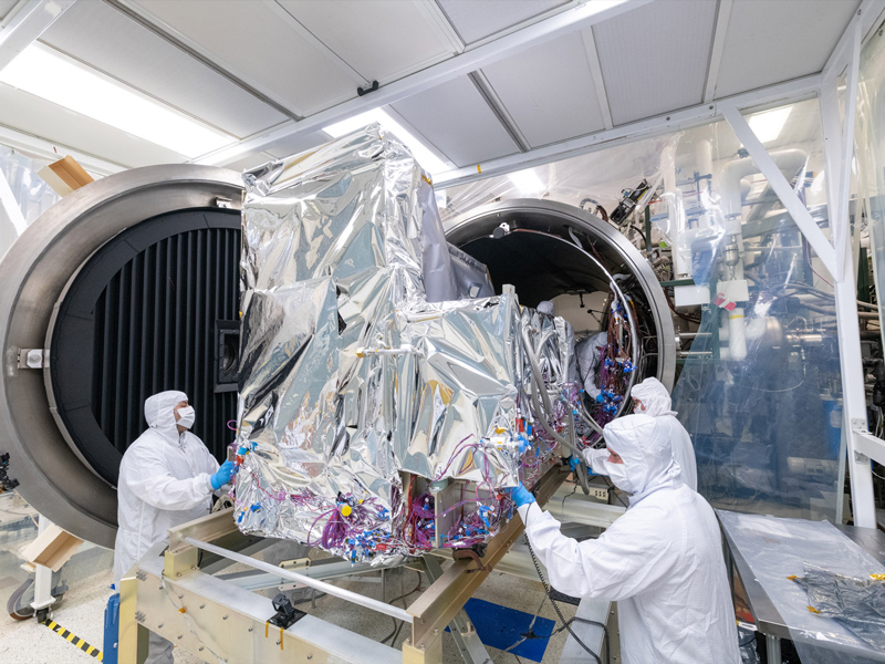 The Ocean Color Instrument team pushes the instrument into the Thermal Vacuum Chamber (TVAC) for environmental testing. Credit: Stover, Desiree
