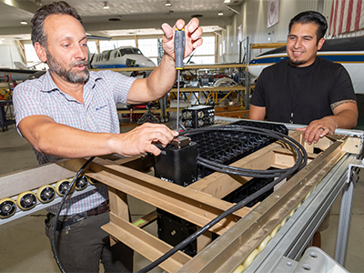 Instrument Scientist Tom Ellis and ER-2 crew chief Juan Alverez prepare the PICARD imaging spectrometer for flight on the NASA ER-2 at the NASA Armstrong Flight Research Center in Lancaster, CA. 