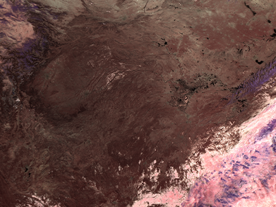 Ice clouds and snow are purple, liquid clouds are pink, water is black, barren ground is brown, and vegetated areas are deep red (at upper right, for example). This image maps 1.6, 2.1, and 2.2 micron band reflectances into red, green, and blue channels respectively. Credit: NASA