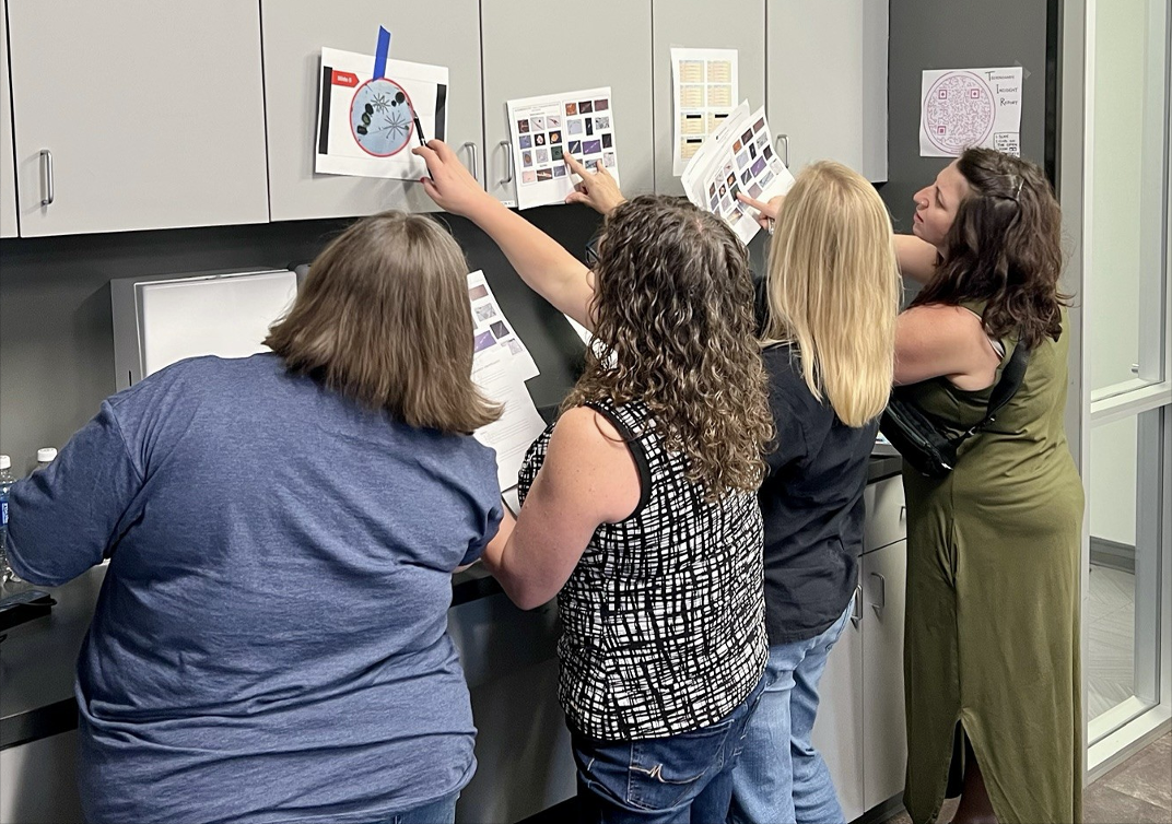 Several teachers comparing papers.