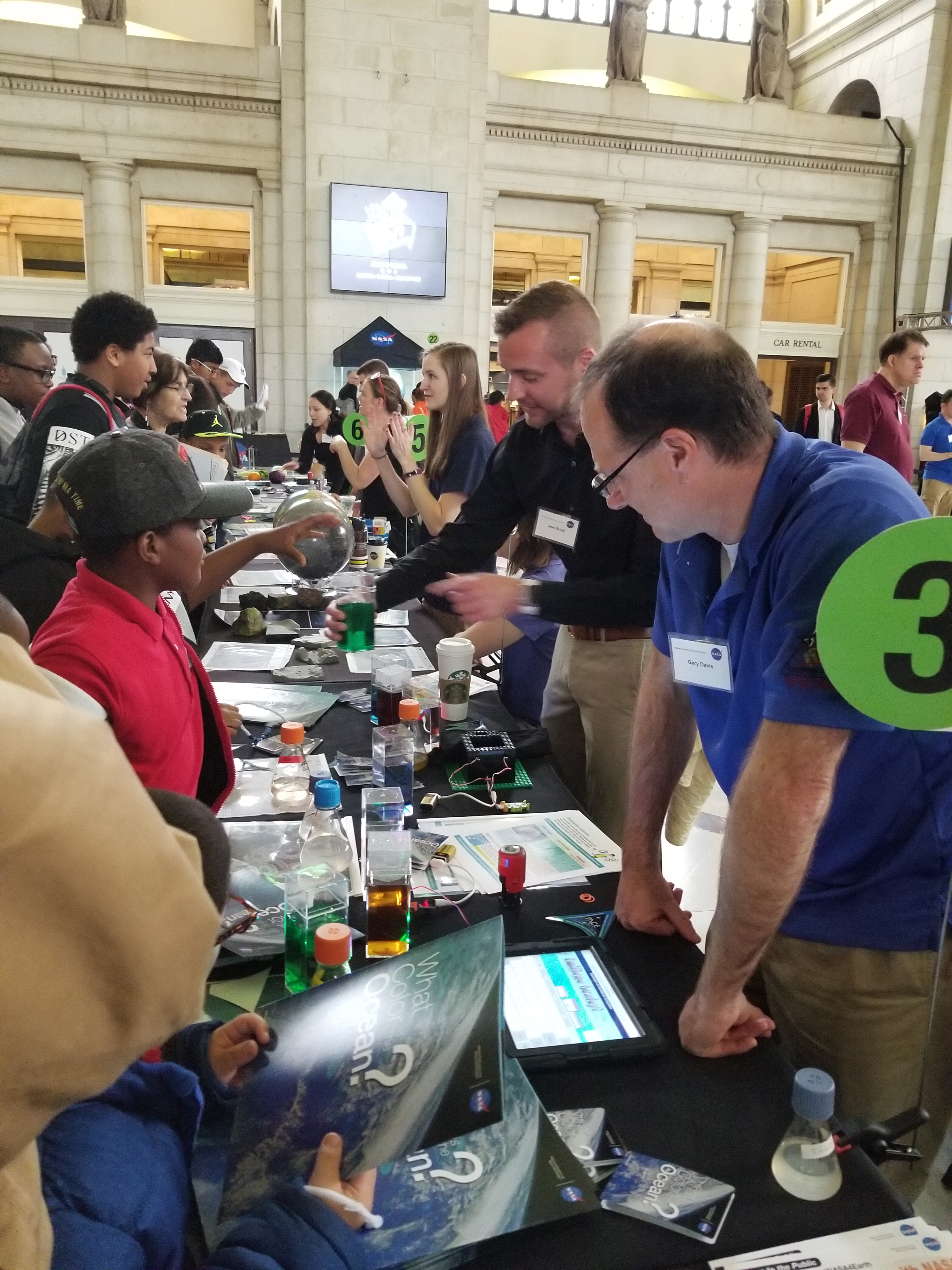 Visitors at the NASA Earth Day Celebration at Union Station (Washington D.C.) check out water with different optical properties while learning about PACE ocean color measurements.