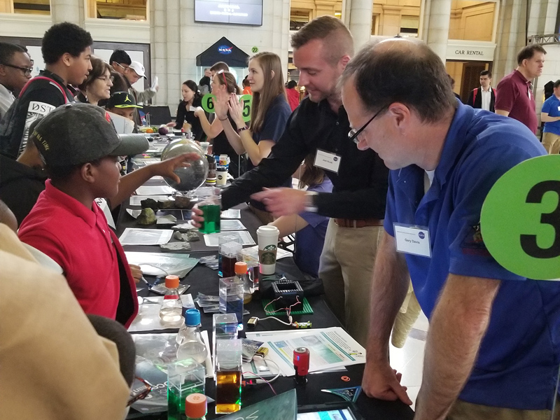 Visitors at the NASA Earth Day Celebration at Union Station (Washington D.C.) check out water with different optical properties while learning about PACE ocean color measurements. Credit: NASA GSFC