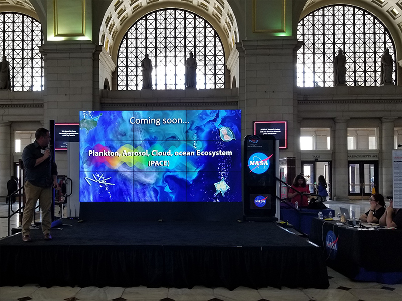 Dr. Jeremy Werdell, PACE Project Scientist, presents a hyperwall talk at the 2018 NASA Earth Day event at Union Station in Washington D.C. Credit: NASA PACE