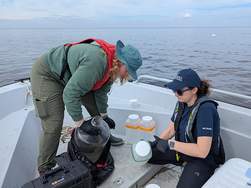Kendra Herweck and Emily Hyland pouring off water samples to take back to the lab for filtering in Green Bay. With a special pel