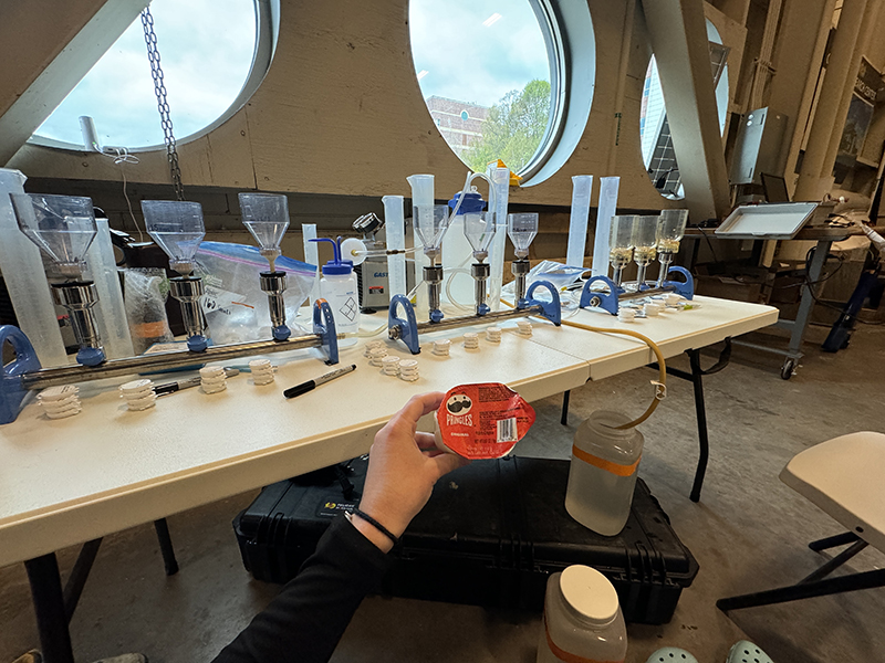 Emily Hyland taking a break to snack and represent the PRINGLS mascot before filtering water samples