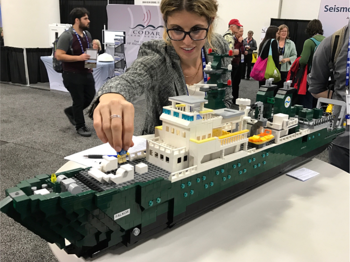 Carlie Wiener (SOI) examines a model of the <em>R/V Falkor</em> made out of legos